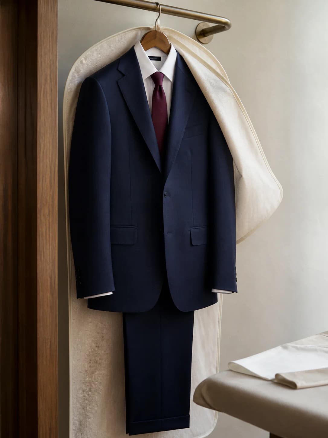A two-piece suit pressed under a cloth and hung ready for an interview