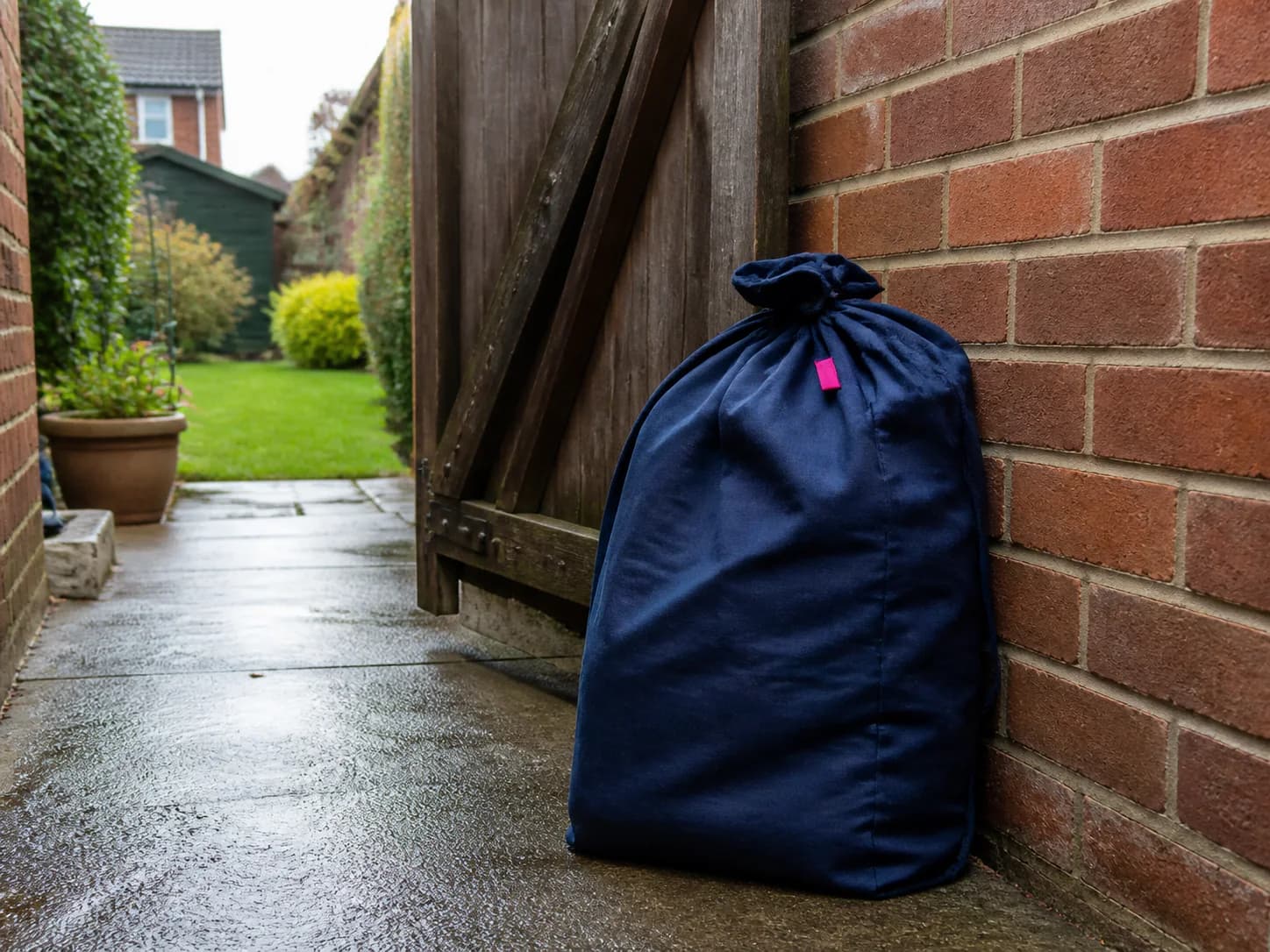A laundry bag left securely in a sheltered side passage for collection